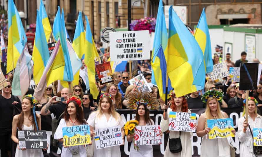 Pride in London march participants holding flags in support of Ukraine.