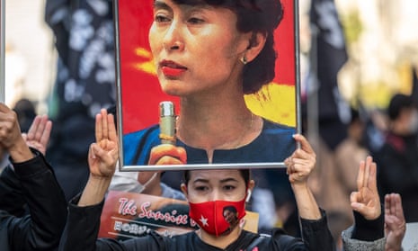A pro-democracy activist holds a picture of Aung San Suu Kyi during a protest in Tokyo