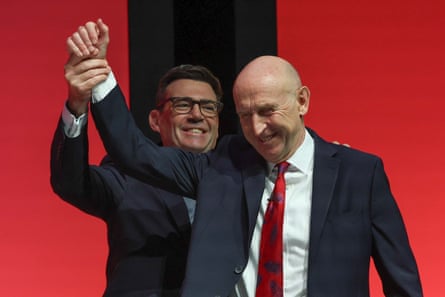 Andy Burnham and John Healey smiling together on the conference stage