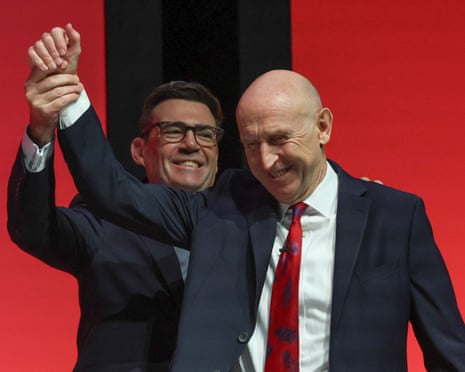Andy Burnham holds John Healey's hand in the air.