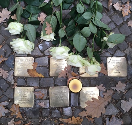 A candle and roses laid on a set of Stolpersteine in Berlin at a commemorative ceremony marking the 80th anniversary of Kristallnacht.