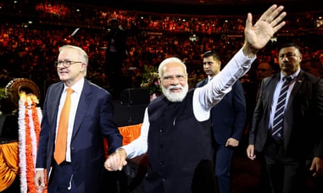 Anthony Albanese and Narendra Modi wave as they leave the crowded stadium