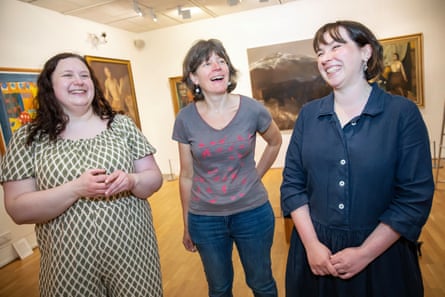 The three women standing and smiling in the gallery