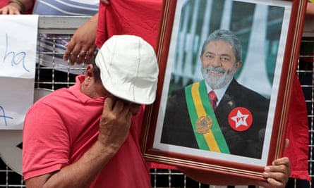 A Lula supporter weeps as he holds a photo of the former president during a rally in São Paulo.