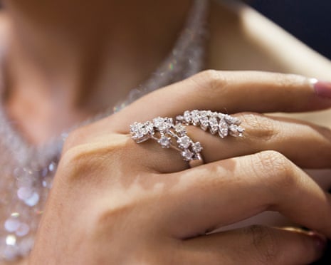 A model presents a diamond ring and necklace