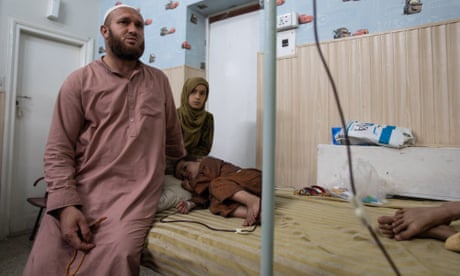 Fareed Ullah sits next to his son Taha, a thalassaemia patient, at Hamza Foundation in Peshawar, Pakistan.