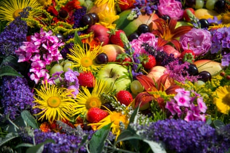 A collection of fruits and garden flowers.