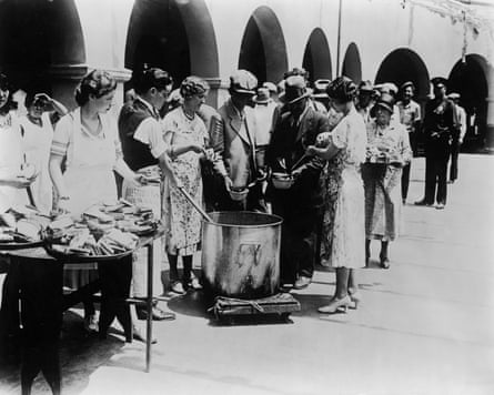 Unemployed men receiving soup and slices of bread at an outdoor breadline during the Great Depression in Los Angeles, California. Some women serve the soup with large ladles while others hand out slices of bread from trays