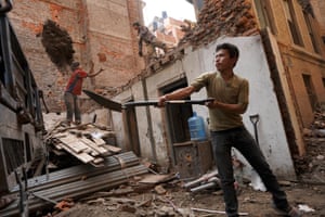 A labourer demolishes a home that was destroyed in the earthquake in Nepal five years ago