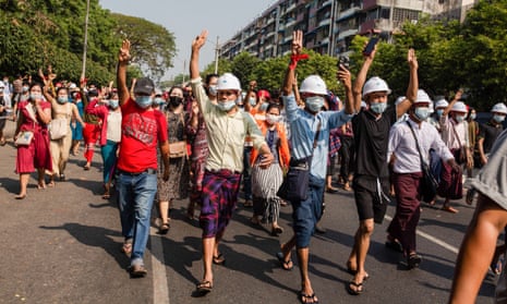 Protesters against military coup in Yangon hold three fingers up.