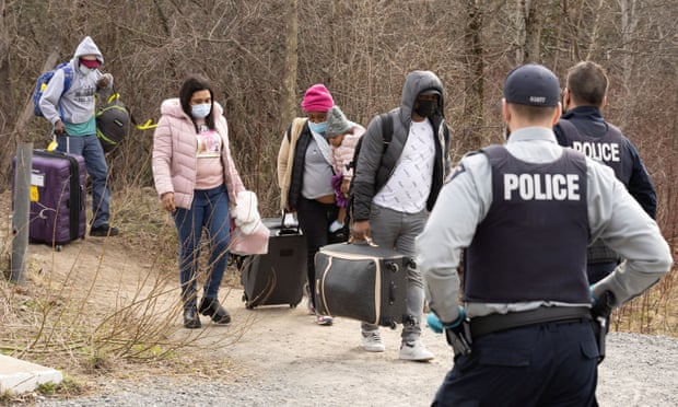Asylum seekers cross into Canada from the US near a checkpoint at Roxham Road near Hemmingford, Quebec.