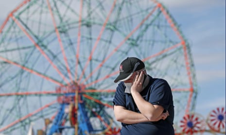 Evan Demaree, an emergency medical services attendant and firefighter holds his phone to his ear while talking to a friend on a windy day at the Coney Island boardwalk in April.