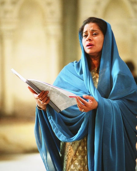 a woman singing while wearing a blue veil