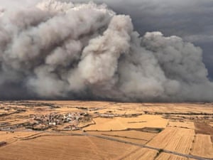 Smoke billows over parched fields