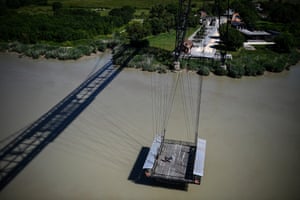 People stand on the hanging gondola of a transporter bridge