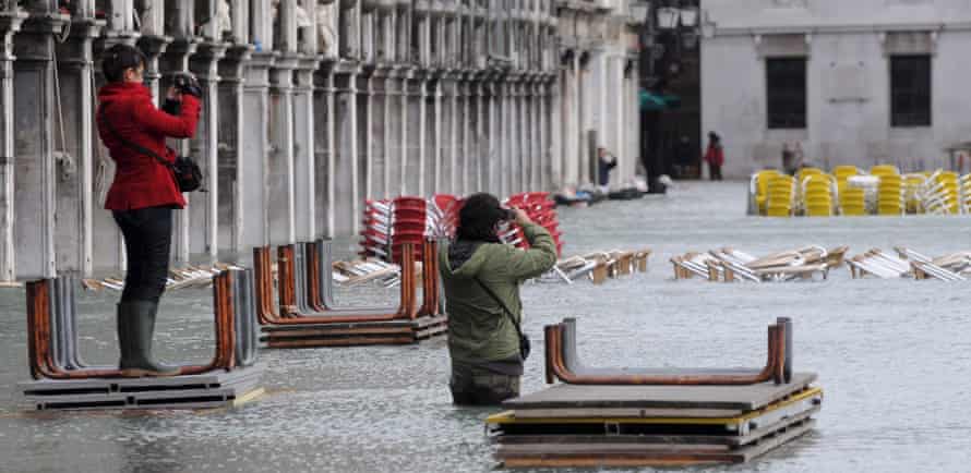 Visitors take pictures in St Mark’s square in December 2008, after it had been hit by one of the highest tides in the city’s history.