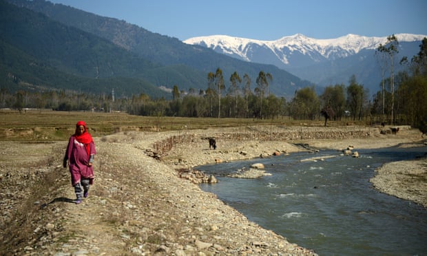 A Kashmiri villager walks past what used to be a pond holding drinking water in the village of Chandigam in the Lolab valley in the foothills of the northern Kashmir Himalayas, where glaciers are melting fast.