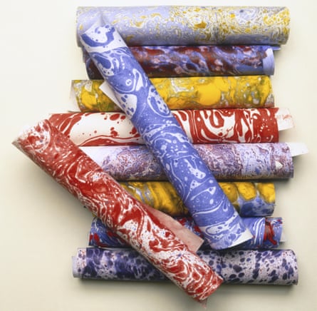 Colourful selection of stacked marbled paper rolls.