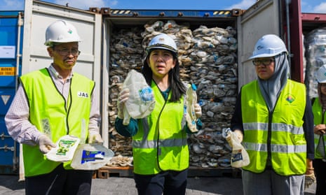 Malaysia’s environment minister, Yeo Bee Yin, centre, in front of a plastic waste shipment from Australia