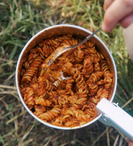 Fusilli pasta in a tomato sauce in a saucepan in the field.