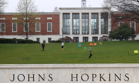 A couple throw a frisbee for a dog on the real-life Johns Hopkins University campus.