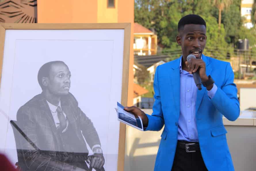 The artist Martin Senkubuge discusses a drawing of Davis Tushabomwe at the exhibition. Tushabomwe is an auditor in Kampala.