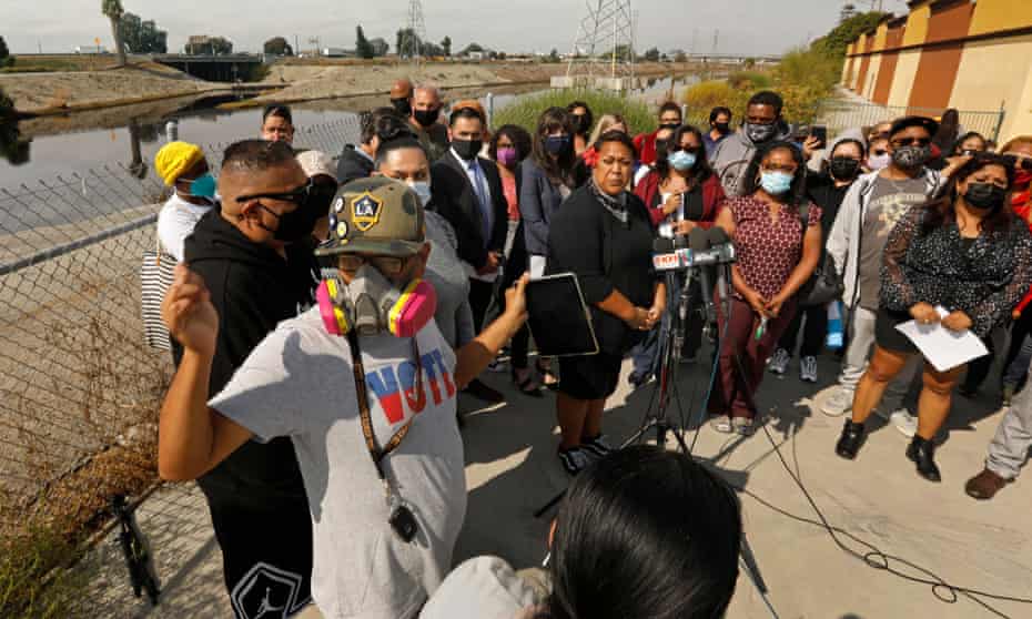 Carson residents gather beside the Dominguez Channel in late October for a press conference about the odor. Many wear masks