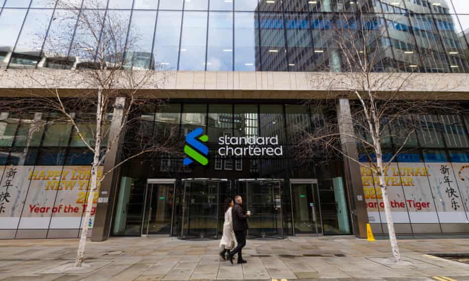 Pedestrians pass the headquarters of Standard Chartered in London