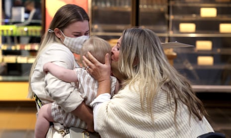 Bienna Diedrichs hugs her mom Milinda Smith with her son Henry Diedrichs as they are reunited at Auckland Domestic Airport 
