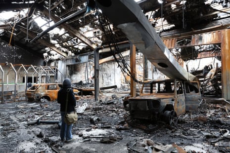 ईरान के तेहरान में एक ऑटो सर्विस सेंटर में वाहनों के मलबे के बीच काम करते मीडिया के सदस्य।