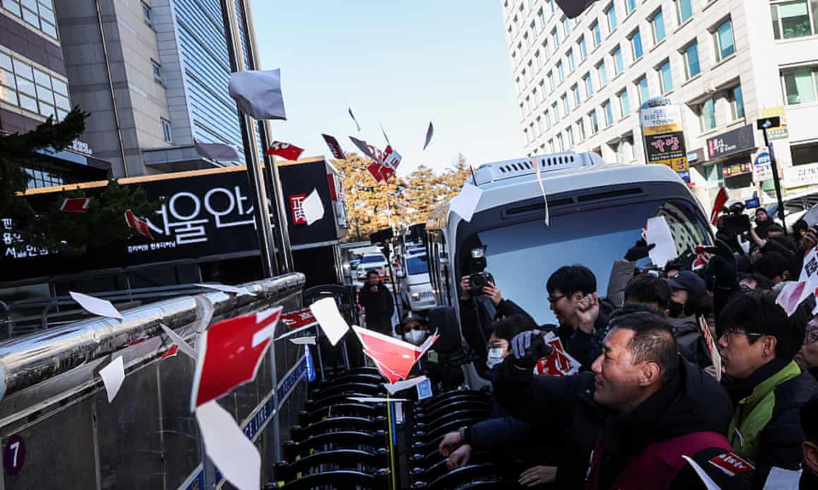 Protesters throw torn signs depicting the names of ruling People Power party lawmakers who did not vote to impeach the South Korean president, Yoon Suk Yeol.