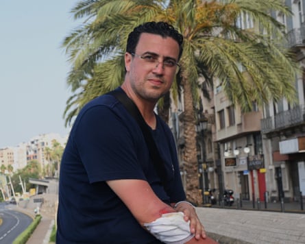 Youssef El Abbas sitting on a wall with a bandage on his injured right arm