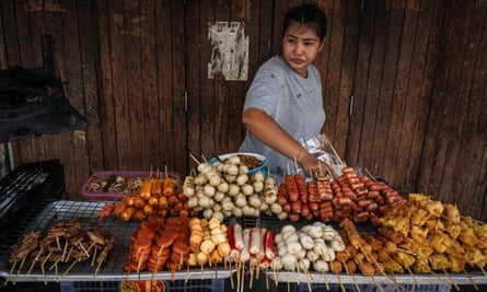 A woman arranges fried snacks on her street food cart the Pratunam district of Bangkok.