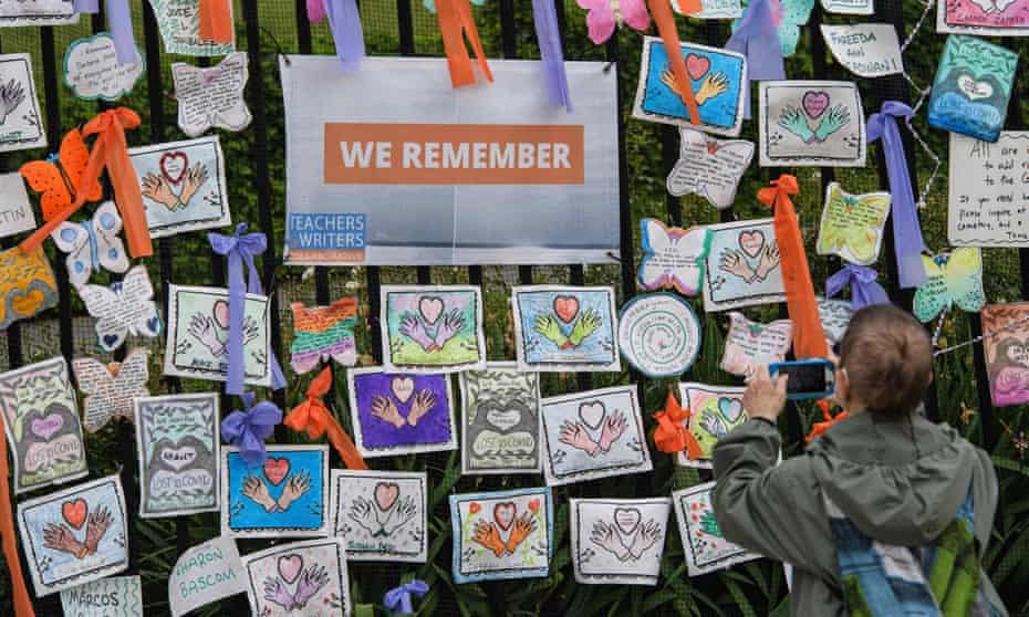 A person takes a photo of an installation remembering lives lost to Covid at the Green-Wood Cemetery in New York City. 