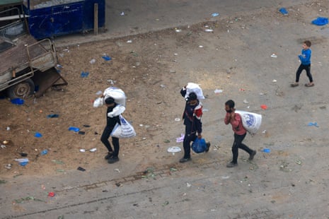 Palestinians carry bags of foodstuff through Rafah in the southern Gaza Strip.