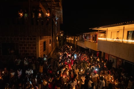 Inhabitants of the Juntas village of the Yurumanguí gather on the street at night holding candles