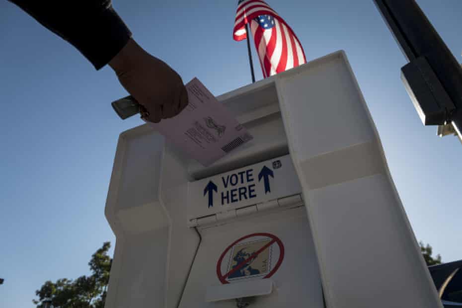 A voter drops an early voting ballot into a collection box at the Contra Costa county clerk office in Martinez, California, on 27 October 2020. 