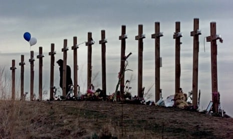 An unidentified woman looks at 15 crosses posted on a hill above Columbine high school in Littleton, Colorado.