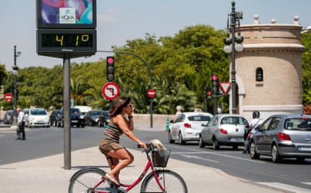 A cyclist waits to cross a road in Valencia, Spain, where the temperature is 41C.