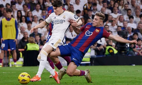 Fermin Lopez of Barcelona challenges Fran Garcia of Real Madrid in match at Santiago Bernabeu Stadium on Sunday