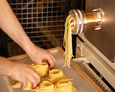 A chef using a pasta making machine