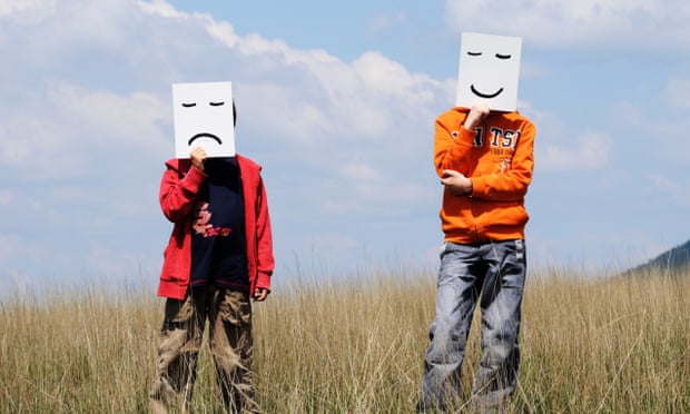 Boys in Field holding Drawn Facial Expressions