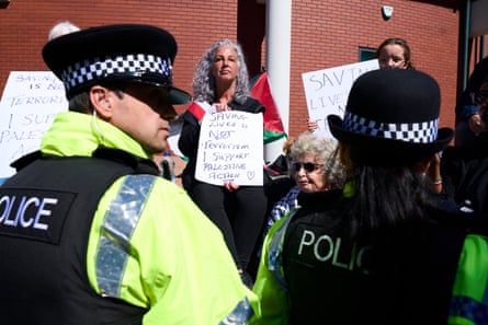 Police officers and supporters of the ‘Barclays five’ holding placards