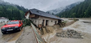 Mud and water surrounds a partially collapsed house