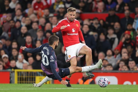 Rodrigo Bentancur of Tottenham Hotspur scissor-tackles Luke Shaw of Manchester United.