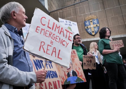 People hold banners saying, ‘Climate emergency is real’, ‘God save the green’ and ‘Don’t be a fossil fool’