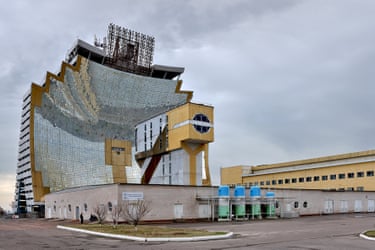 A tall building covered on one side by mirrors