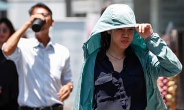 A woman shields herself during hot weather in Bangkok
