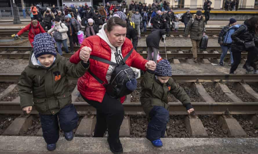 People, mostly women and children, try to get onto a train bound for Lviv, at the Kyiv railway station, Ukraine, Friday, March 4, 2022. (Russia’s war on Ukraine is now in its ninth day and Russian forces have shelled Europe’s largest nuclear power plant, sparking a fire there that was extinguished overnight. (AP Photo/Andriy Dubchak)
