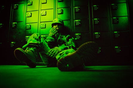 woman sits on the floor in a green-lit room